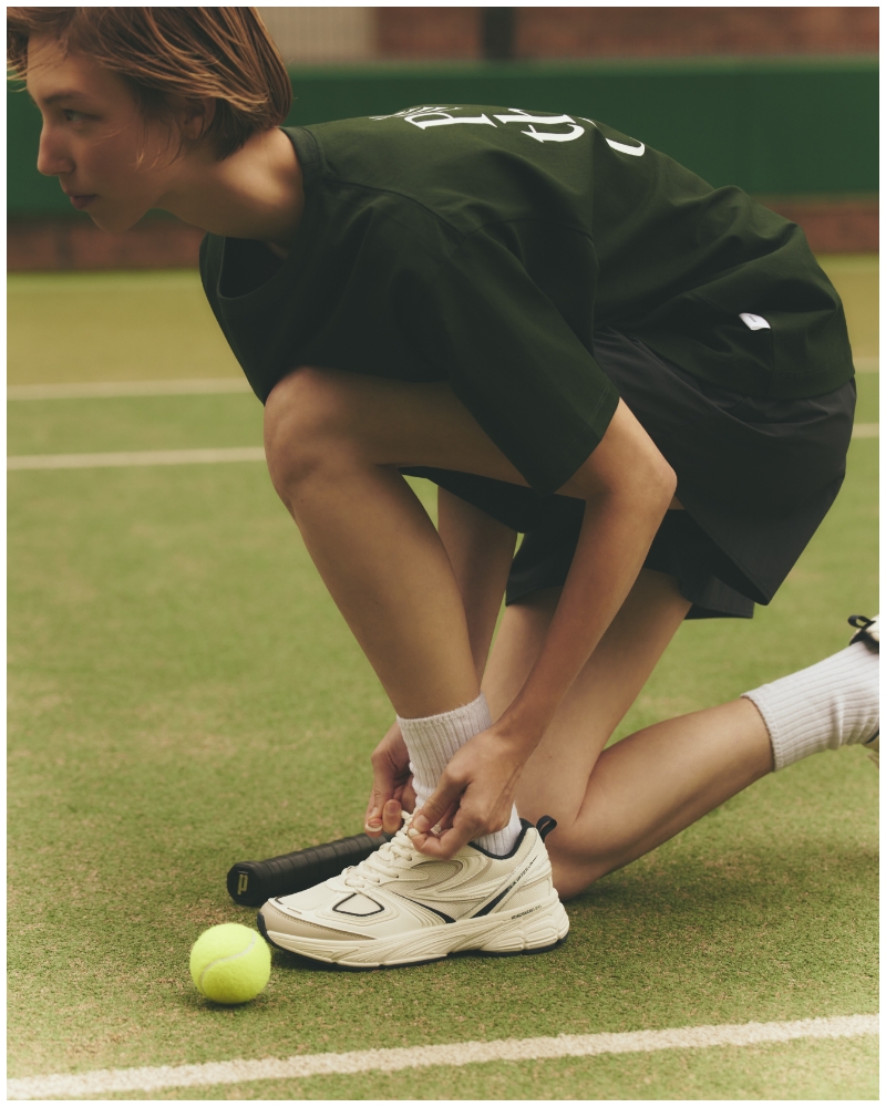 【prince|emmi】グラフィックTシャツ・【ONLINE限定カラー】【prince|emmi】ナイロンハーフパンツ・【emmi×FILA】INTERUNを着用した女性