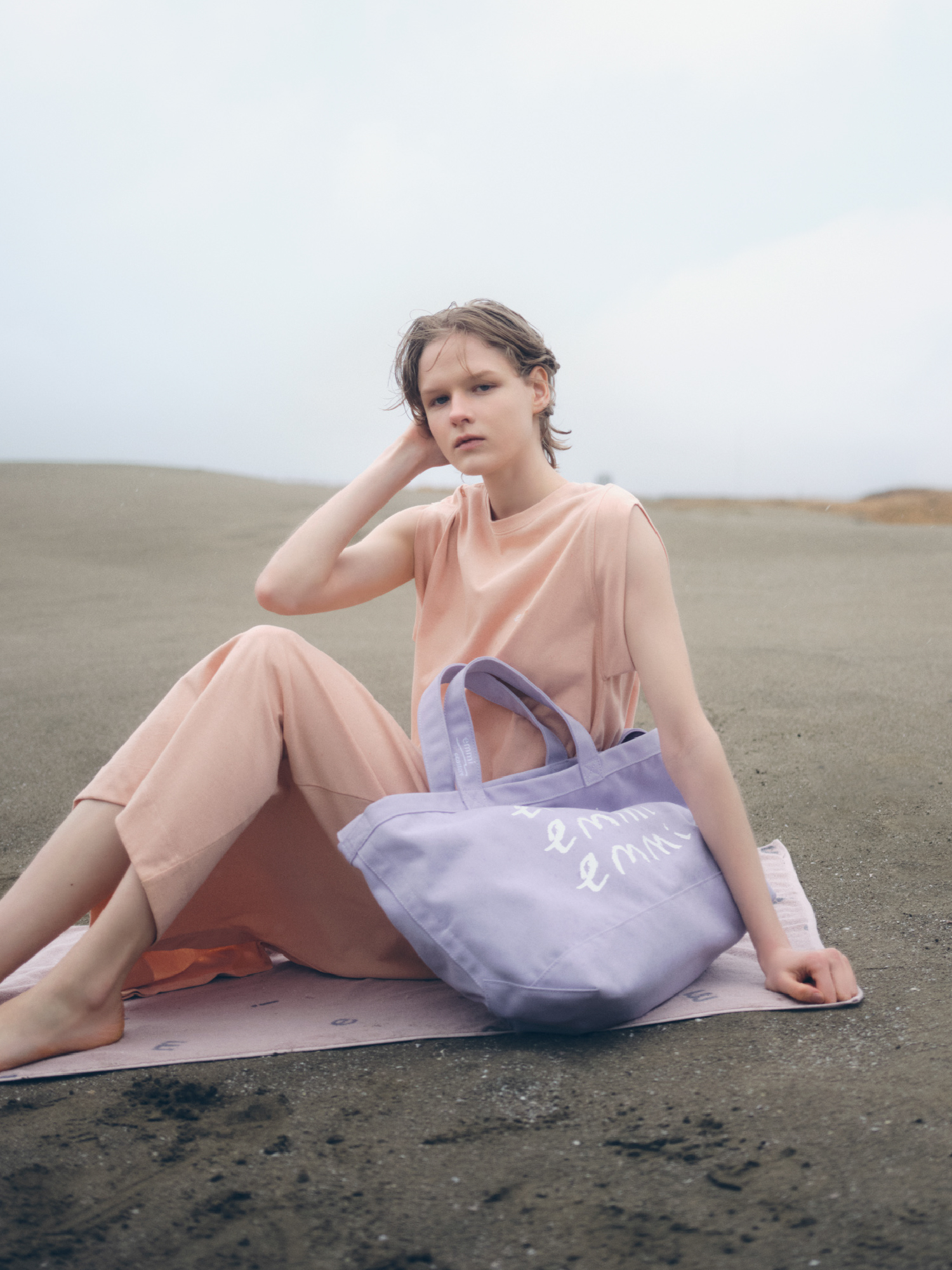 【emmi×ecostore】UpDRIFT emmiロゴワンピース・【emmi×ecostore】eco キャンバストート・【emmi yoga】emmiロゴジャガ－ドバスタオルを着用した女性