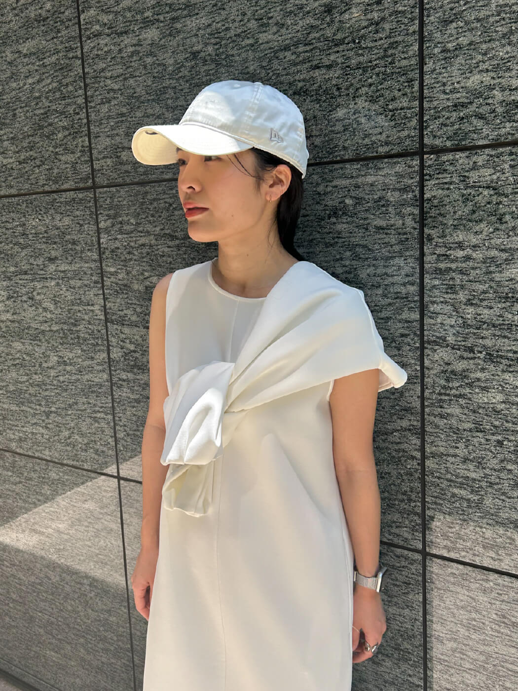 白色のレイヤードダンボールワンピースと【emmi|NEW ERA®】9TWENTY™サテンキャップを着用したモデル画像