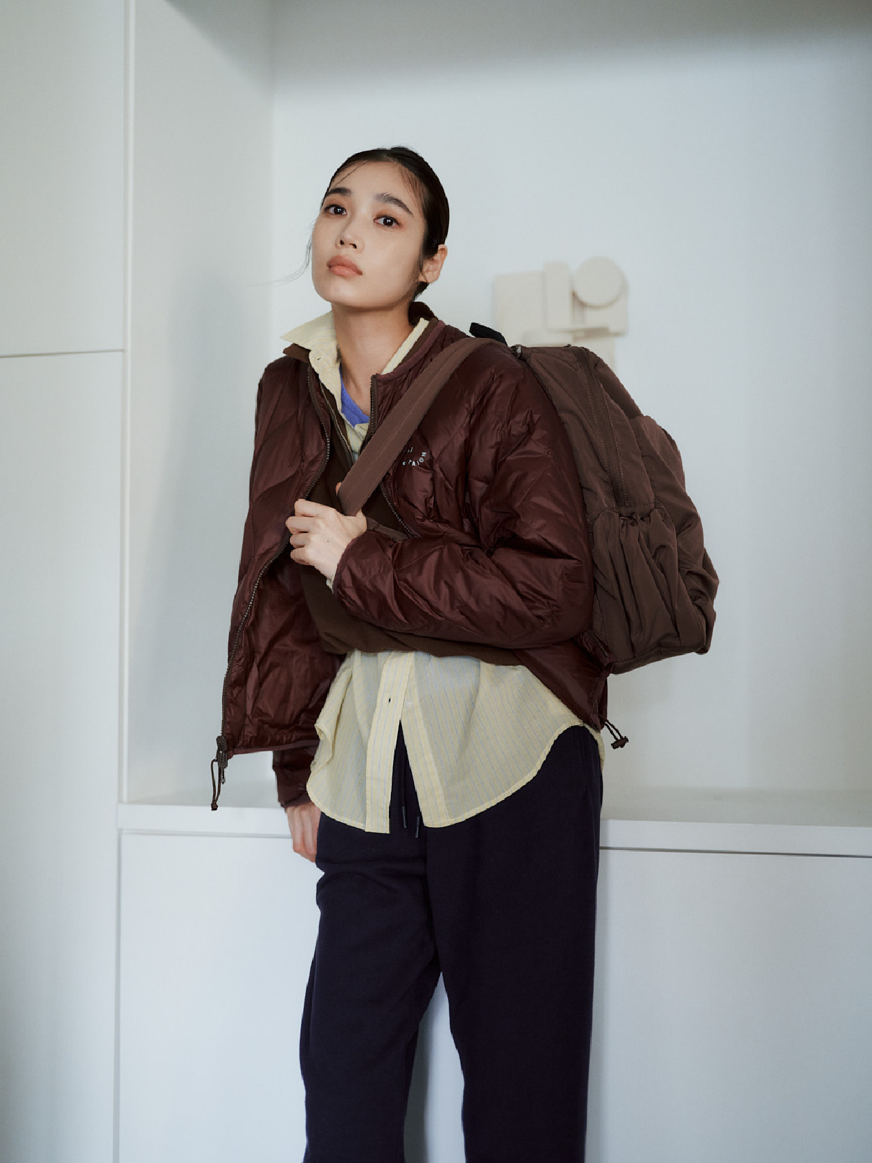 emmi×TAIONリバーシブルダウン、ジップアップニット×スカートセット、シアーストライプシャツ、シアーニットトップス、エンブレムロゴ スウェットパンツ、【ONLINE限定カラー】eco 撥水ギャザーボディーバックパックの着用イメージ