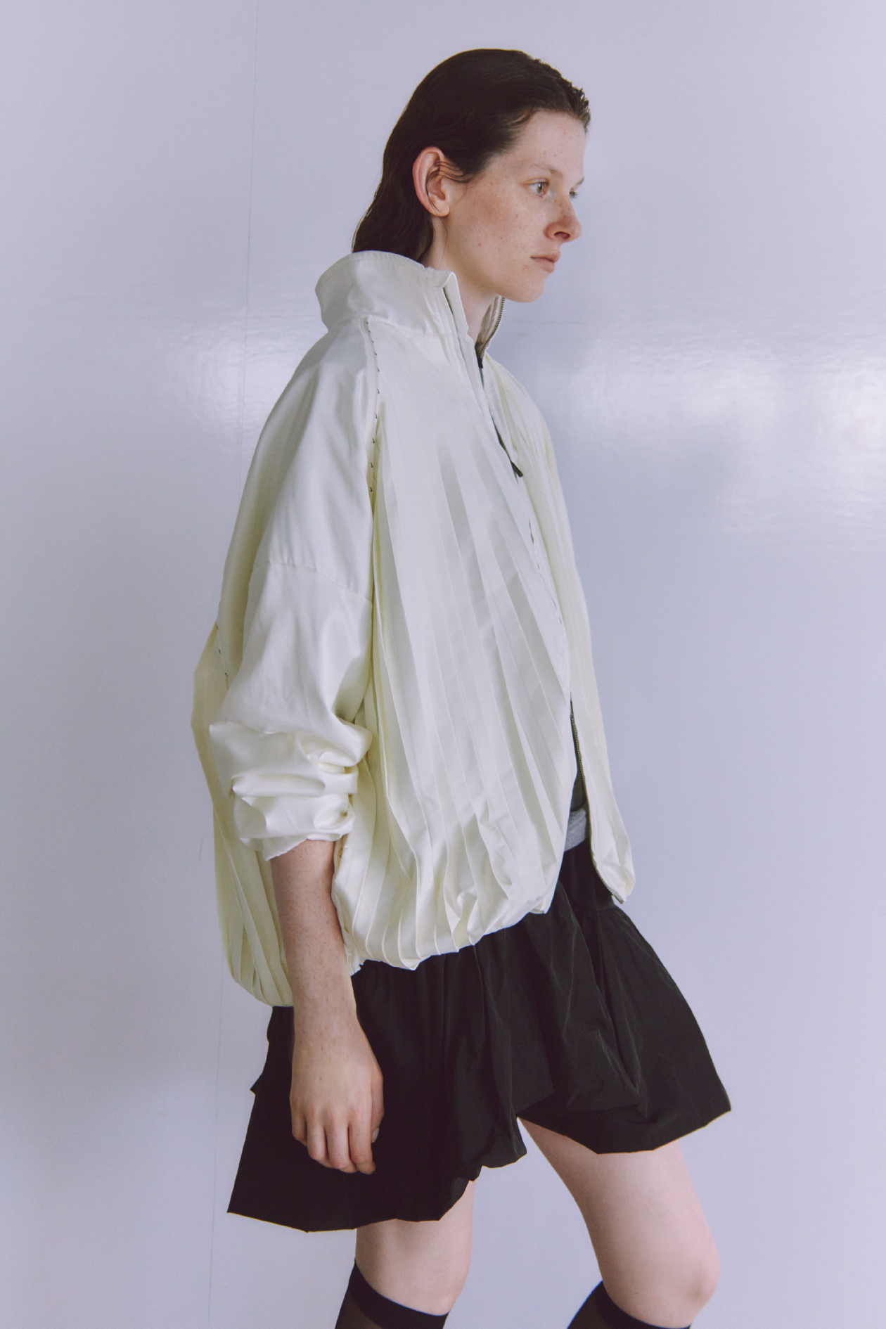 AS W NSW CLLCTN PLEATD TRK JKT・グラフィックリンガーTシャツ・ドッキングミニワンピース・【NIKE meets emmi】WMNS AIR MAX MUSE SEを着用した女性の画像