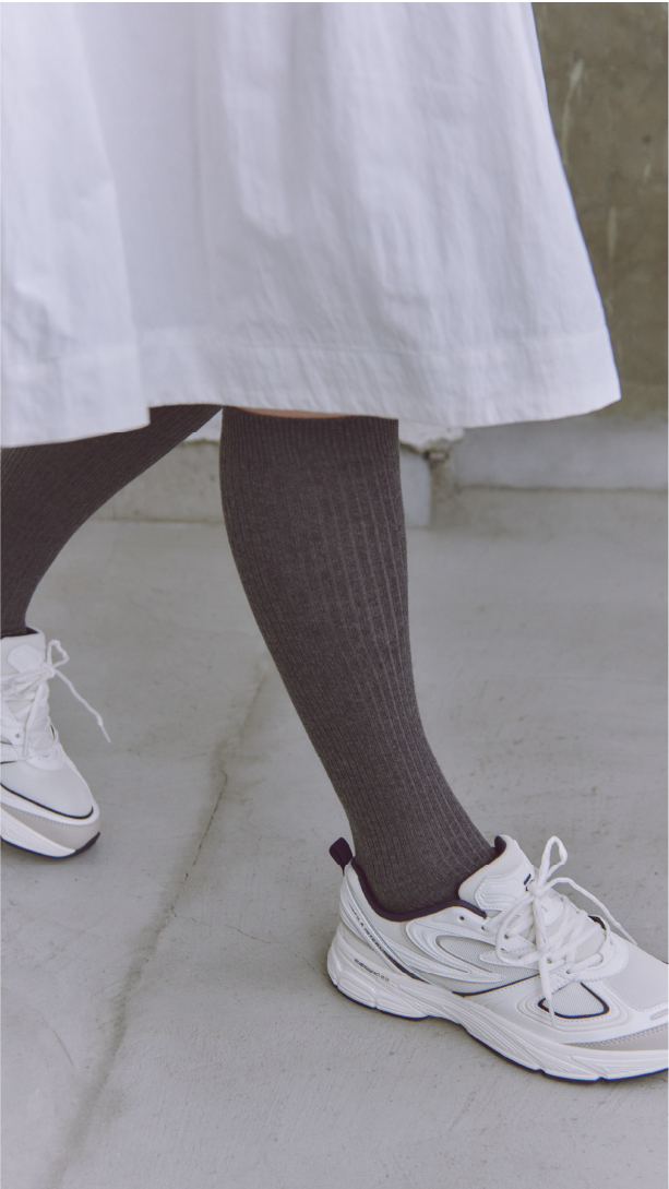 コットンリブハイソックス・FILA INTERUN X emmiを着用した女性の足元
