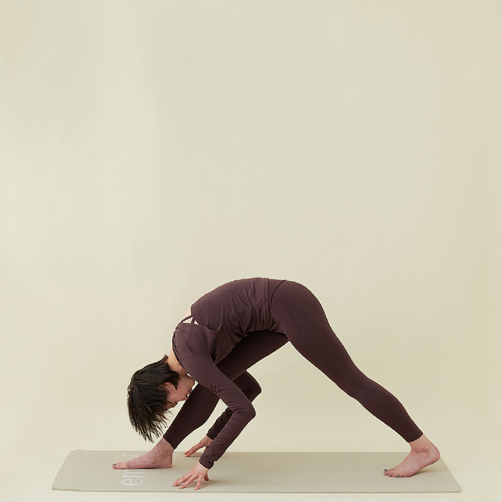7：息を吸いながら右脚のヒザを伸ばし、吐きながら上体を倒してパールシュヴォッターナサナ(両脚を前後に広げ、強く伸ばした前屈)。