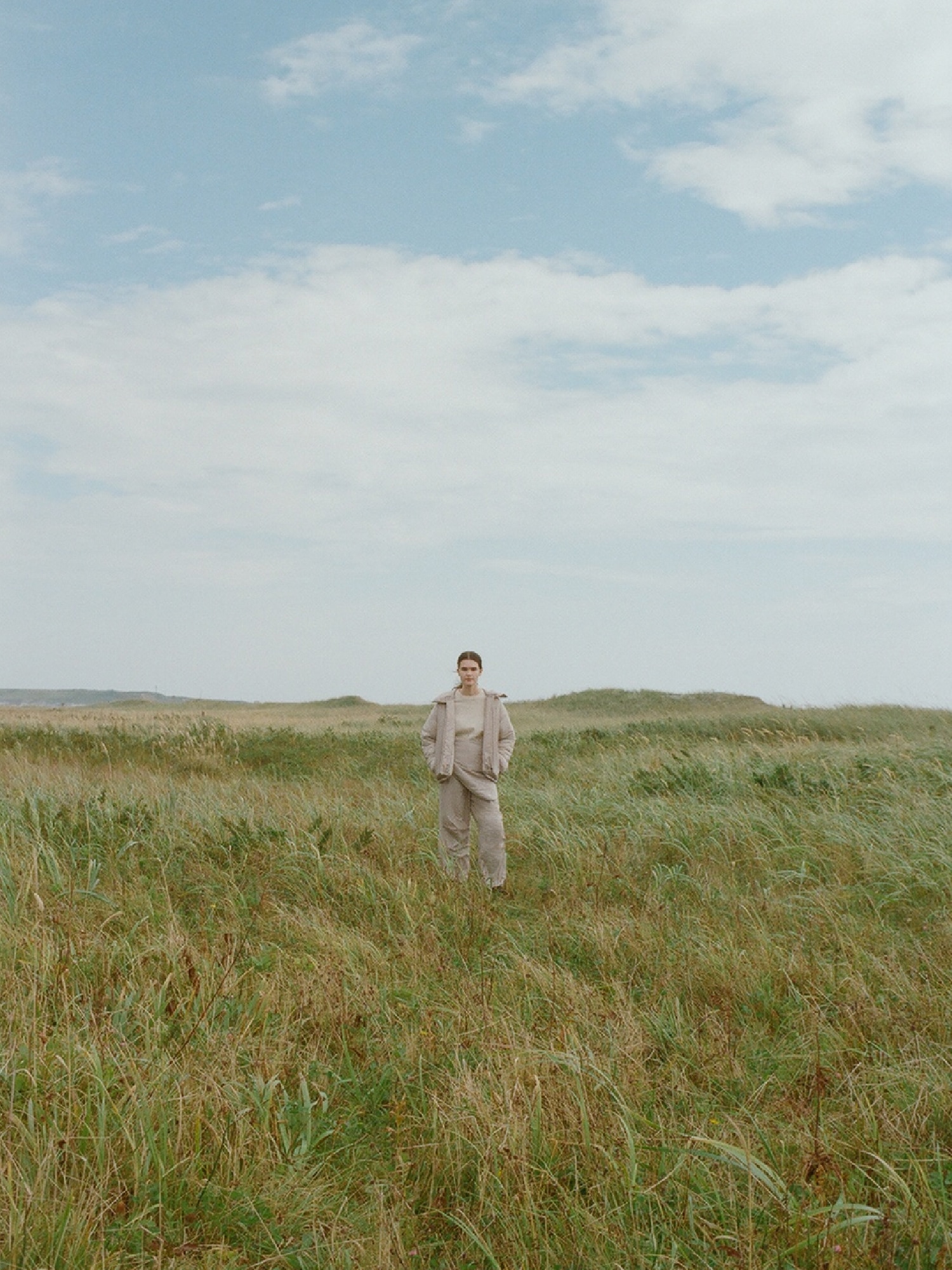 emmi | Mizunoのトータルコーディネートで草原に佇むイメージ写真