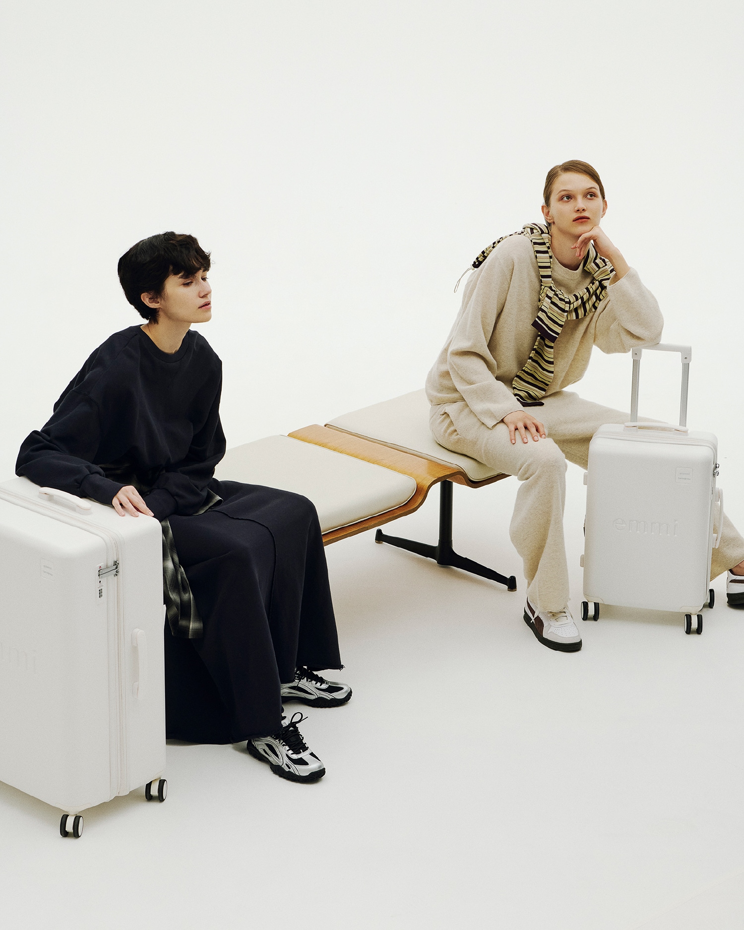 ベンチに座り談笑する二人のビジュアル。（着用アイテムは下クレジットに記述）