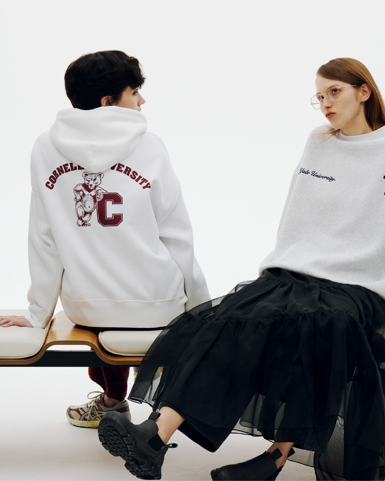 ベンチに腰掛ける男女のイメージ画像（着用アイテムは下クレジットに記述）