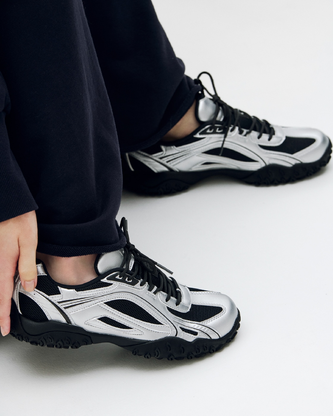 ネイビーのスウェットマキシスカートとemmi×FILAのシューズを着用した女性の足元写真