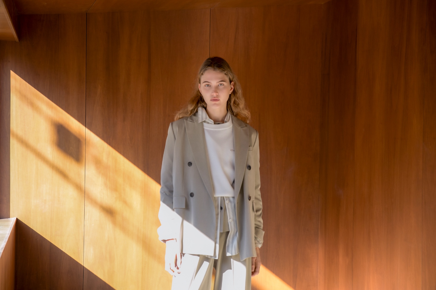 オリーブのダブルブレストテーラードジャケットとジレトップスと
ワイドレッグタック入りパンツ・白の7daysドロストニットトップス・ストライブのemmiロゴベーシックシャツ・ブラウンのフェザーヤーンニットブーツを着用したコーディネート例1