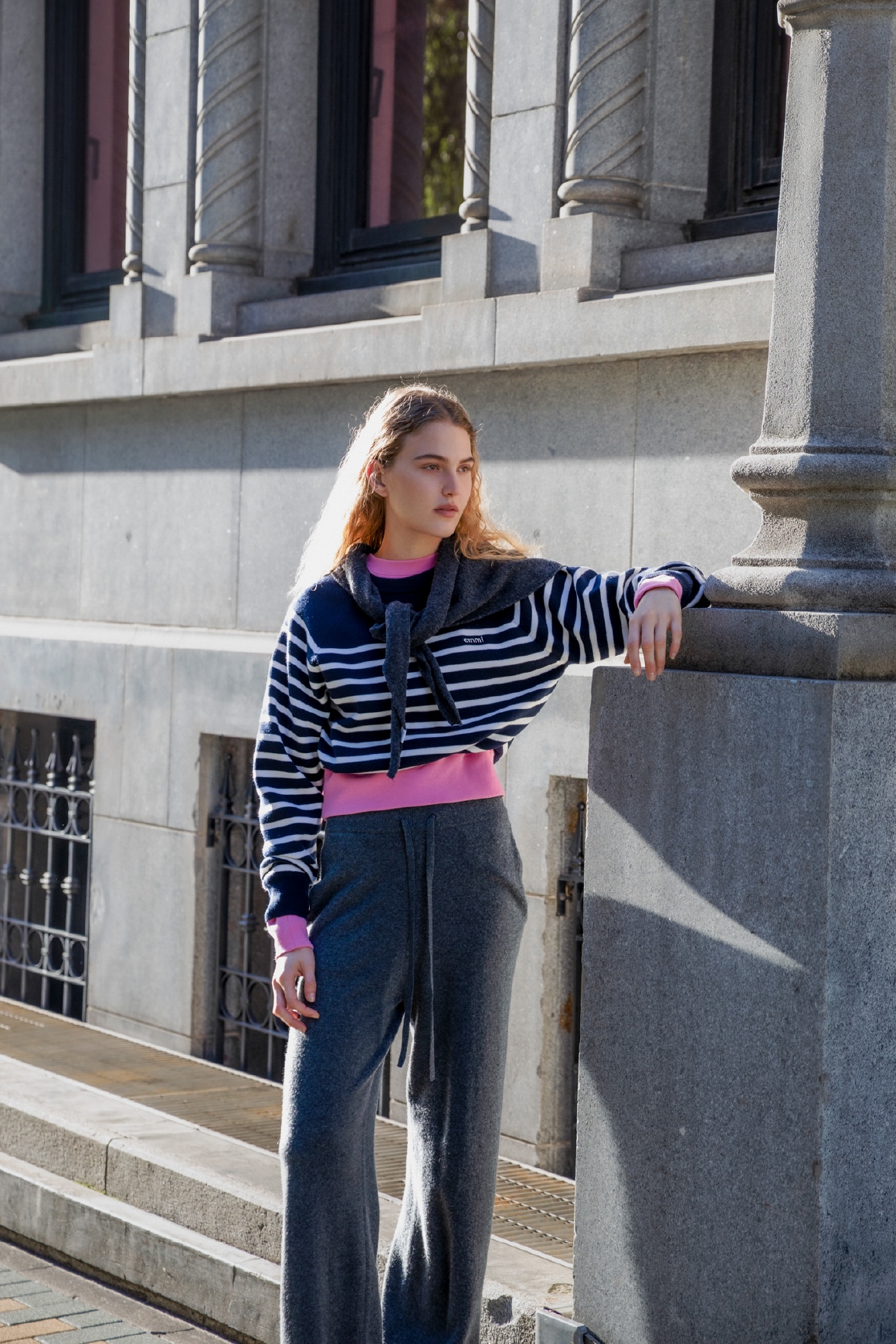 ダークネイビーの7daysドロストニットトップスとウールニットトライアングルスカーフ・ピンクのエンブロイダリーemmiロゴスウェット・グレーのラムウールニットパンツ・ライトベージュの【emmi×SHAKA】TREK SHORT CHELSEAを着用したコーディネート例1