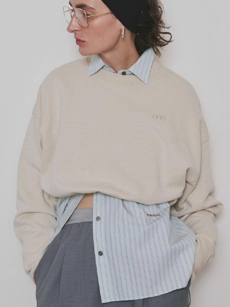 ライトベージュ色のラメ裏毛クロップドプルオーバー、【ONLINE限定カラーあり】ストライプベーシックシャツ、emmiロゴゴムジャガードイージーパンツを着用したモデル画像