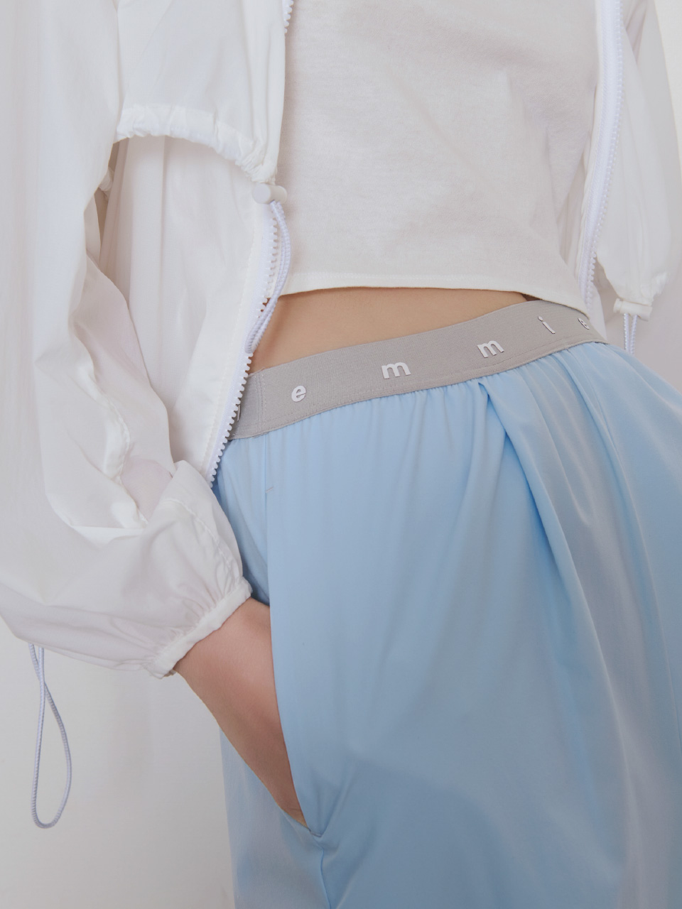 白色のドロストナイロンブルゾン/撥水【セットアップ対応】と【Hanes×emmi】パックTシャツ、ブルー色の【Movique】アクティブイージーパンツ/撥水/UVカット/接触冷感の着用イメージ