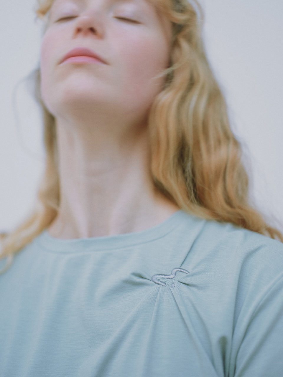 ミント色の【未定】emmiロゴクロップドTシャツ/UVカット/接触冷感を着用した女性のイメージ