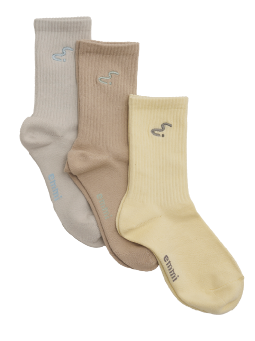 emmi's new symbol "em" markのトータルコーディネートで草原を駆けるイメージ写真