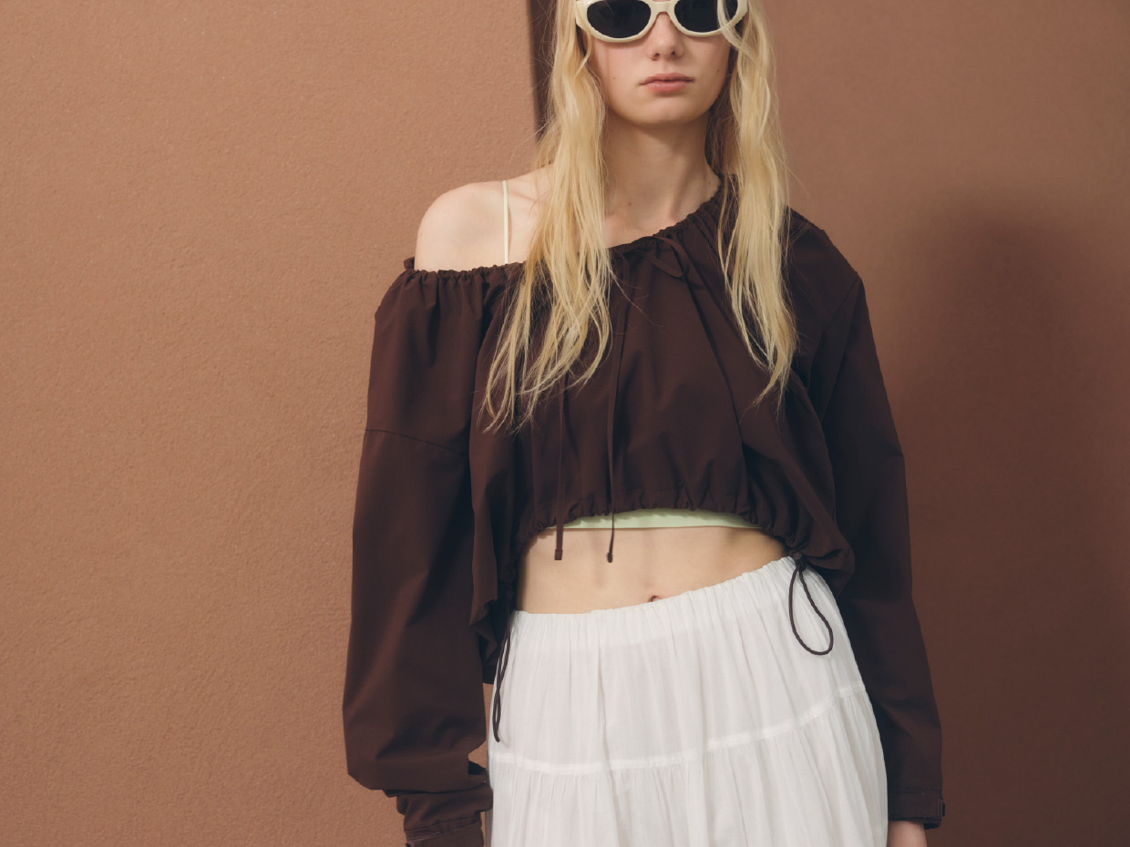 【Movique】ショートフーディー、ティアードボリュームスカート、オーバルキャットアイフレームサングラスを着用したモデル画像