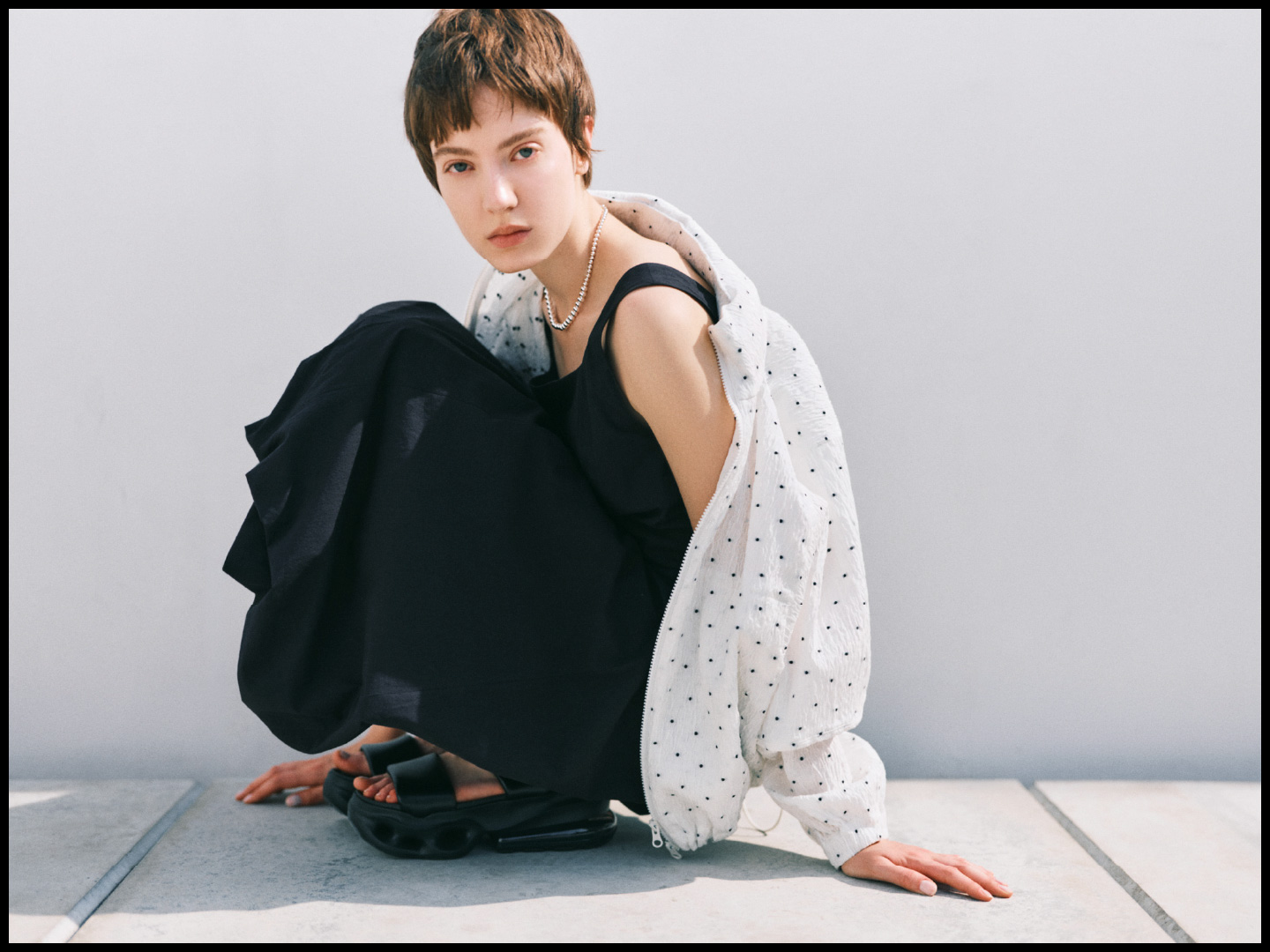 ドットジャガードブルゾン、コットンバルーンワンピース、W AIR MAX HALOを着用して座ってる女性のイメージ