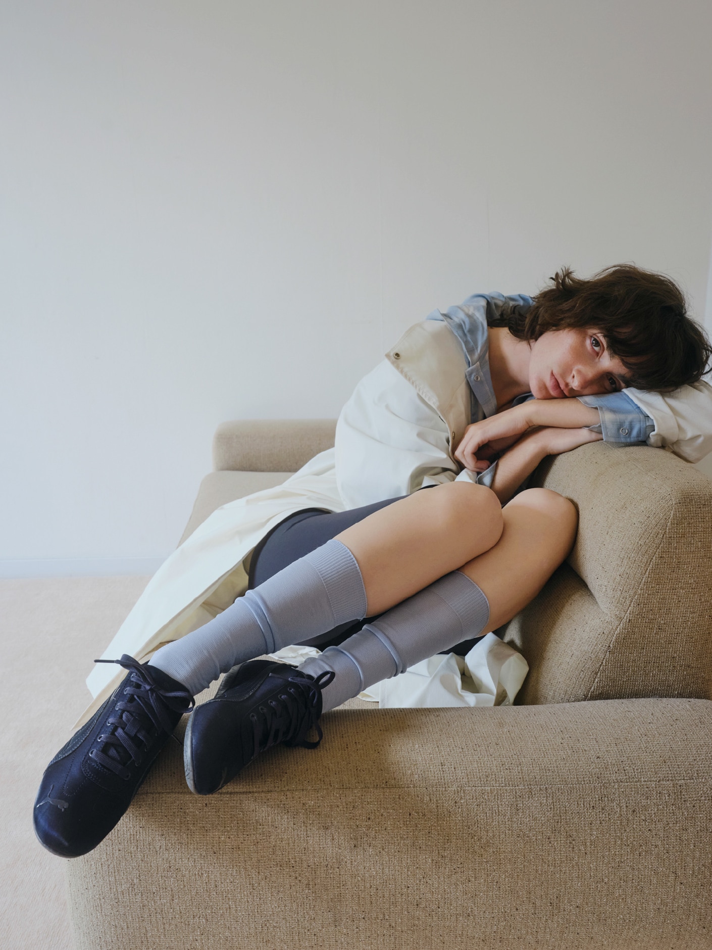 オフホワイトのボリュームスリーブロングコート（撥水）・ライトブルーのチェックフーディーシャツとシアーハイソックス・・黒の【Sustainaretch】ハーフレギンス（UVカット/接触冷感）とSpeed cat satin emmiを合わせた、軽快でヘルシーな印象を与えるコーディネート