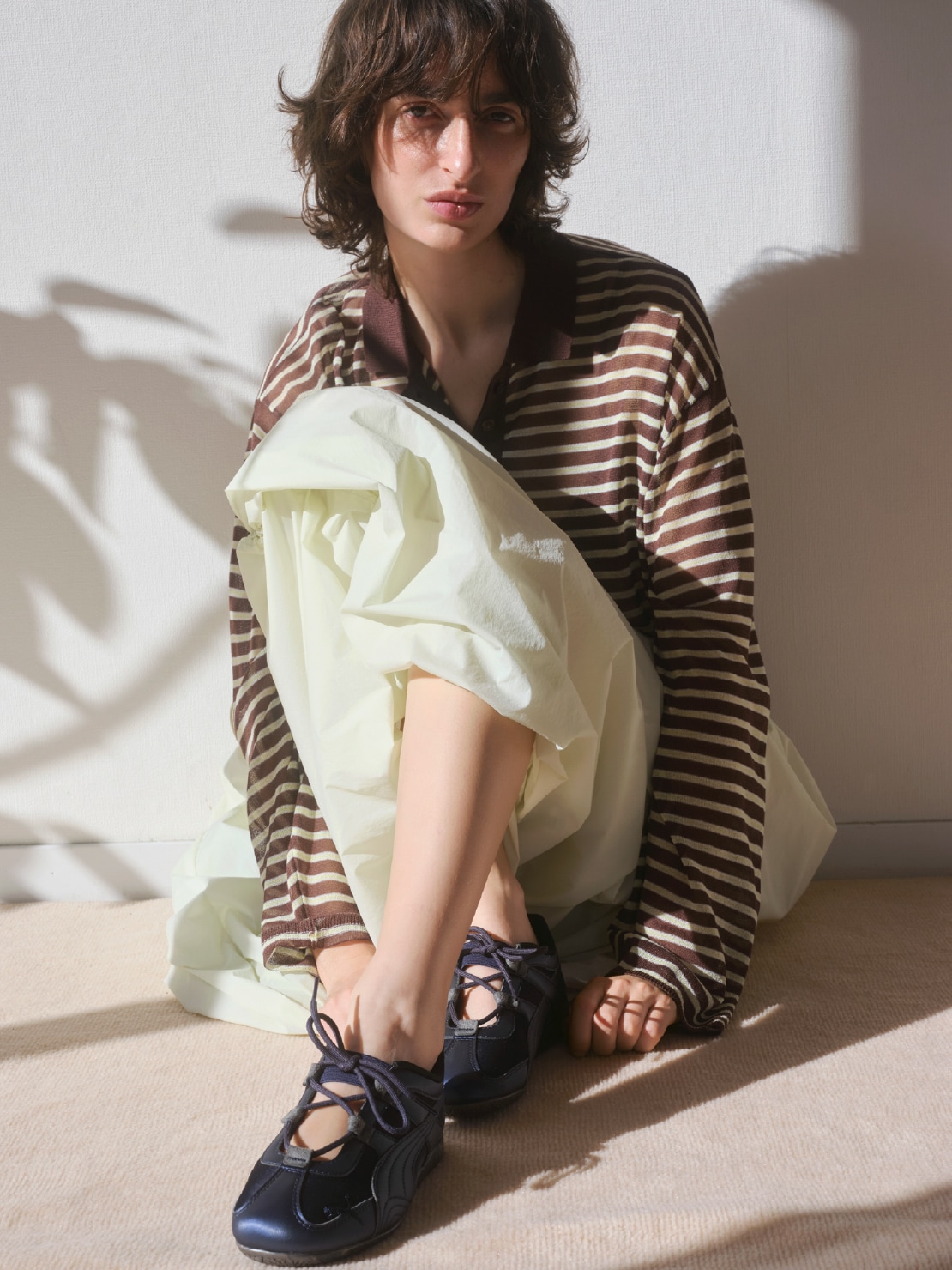 ブラウンのシアーボーダーポロニットとValentine企画ブラ・イエローのドロストバルーンスカート(撥水)・Speed cat Go emmiを合わせた、包み込まれるような心地よい質感が魅力のコーディネート