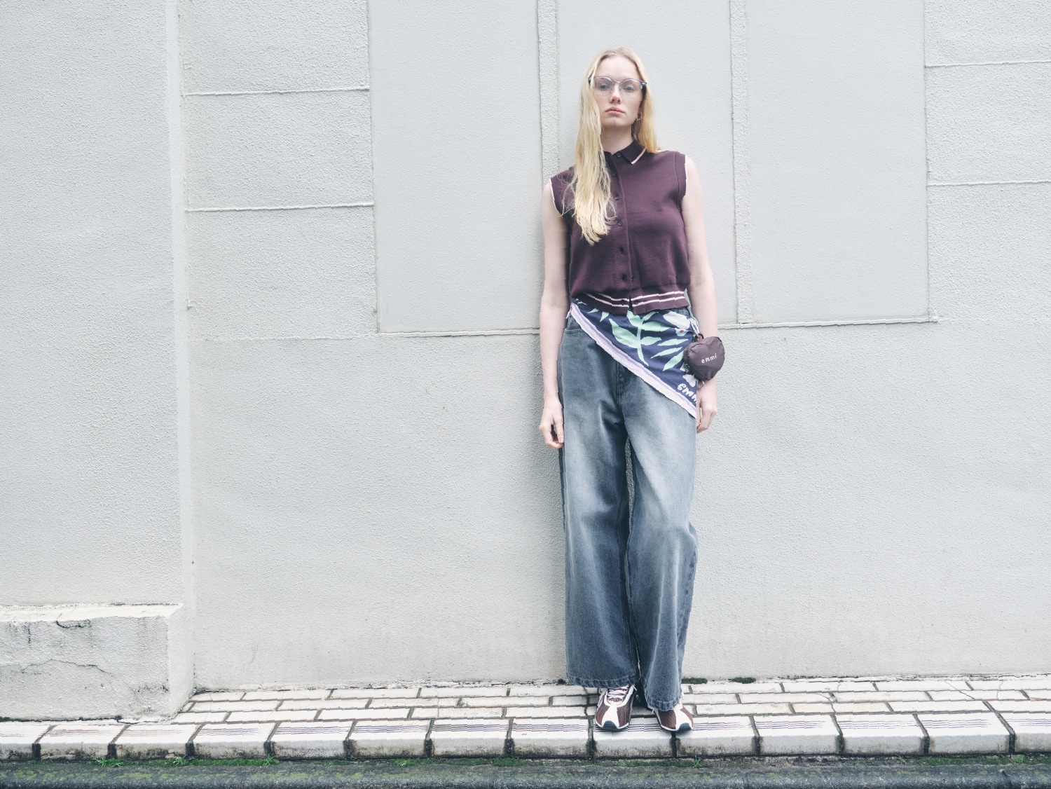 ブラウンの襟付きニットベスト・グレーのウエストゴムルーズデニムパンツ・ネイビーのフラワープリントスカーフ・シルバーのスリムスウィングピアス・ブラウンのエコバッグとH-STREER emmiを合わせたコーディネート