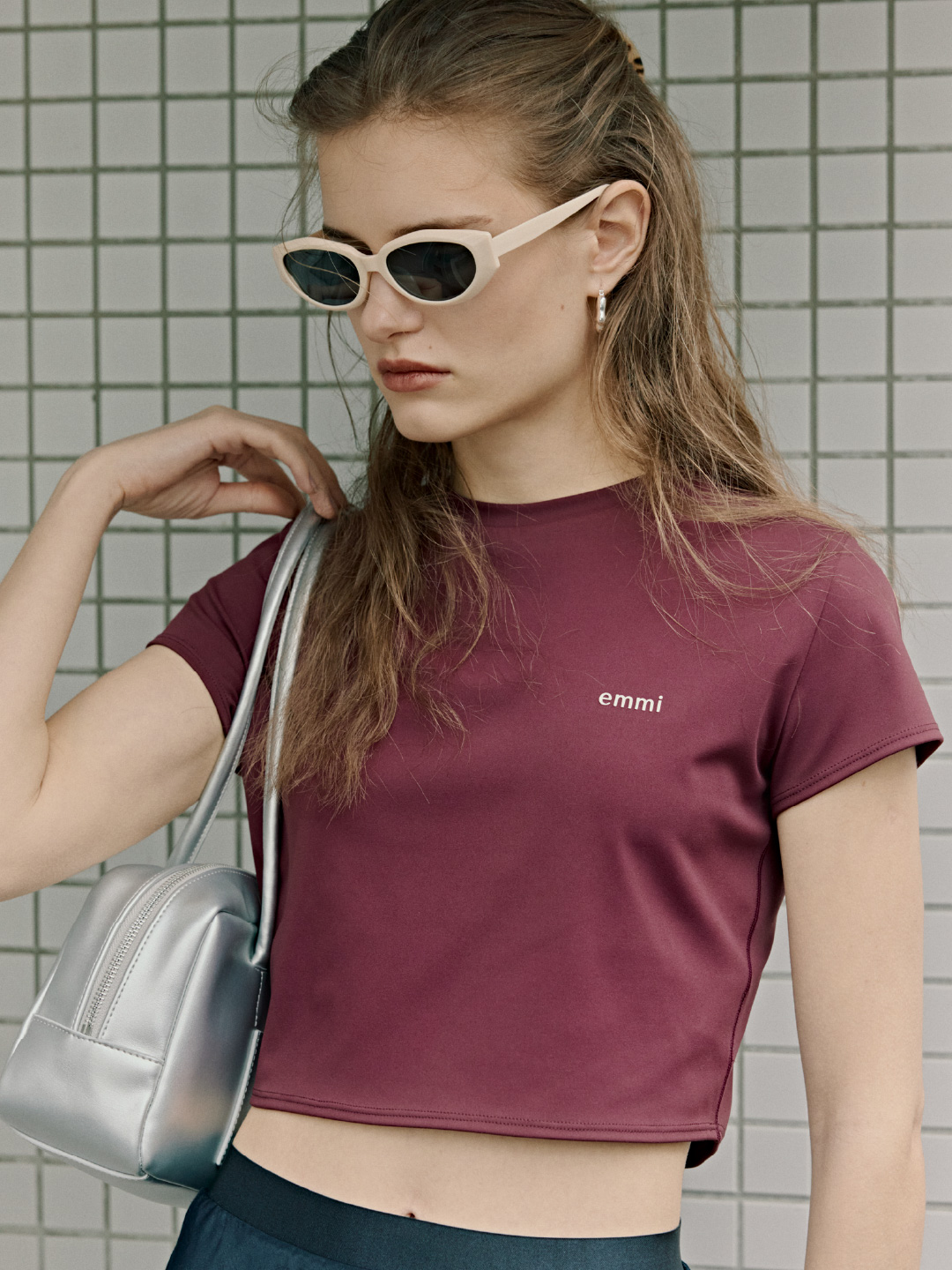 アクティブコンパクトTシャツ、オーバルキャットアイフレームサングラス、フラワーフリルワンタッチピアス、レザーボストンバッグを着用したモデル画像
