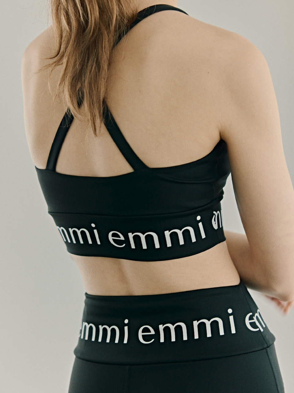 ブラック色のemmiロゴブラトップとemmiロゴレギンスの着用イメージ