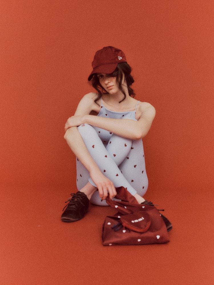 赤いキャップとバッグを持った女性の画像