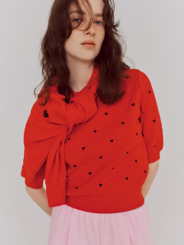 ハート柄の赤いトップスを着た女性の画像
