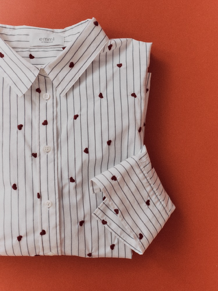 ハート柄でストライプの白シャツが畳まれている画像