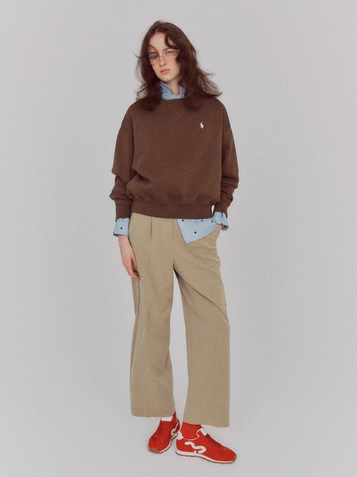 ブラウントップスにベージュのパンツを着た女性の画像