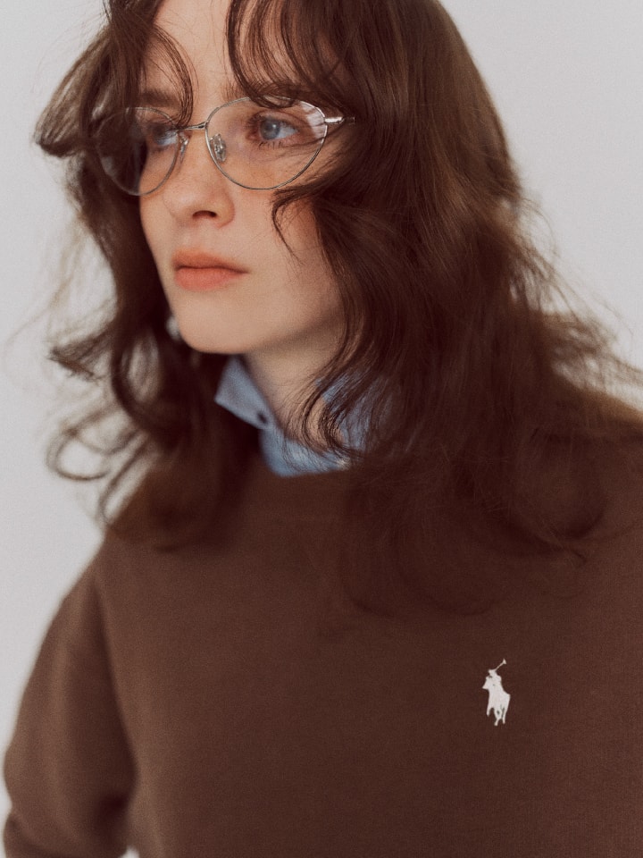 ブラウンのトップスを着てメガネをかけた女性の画像
