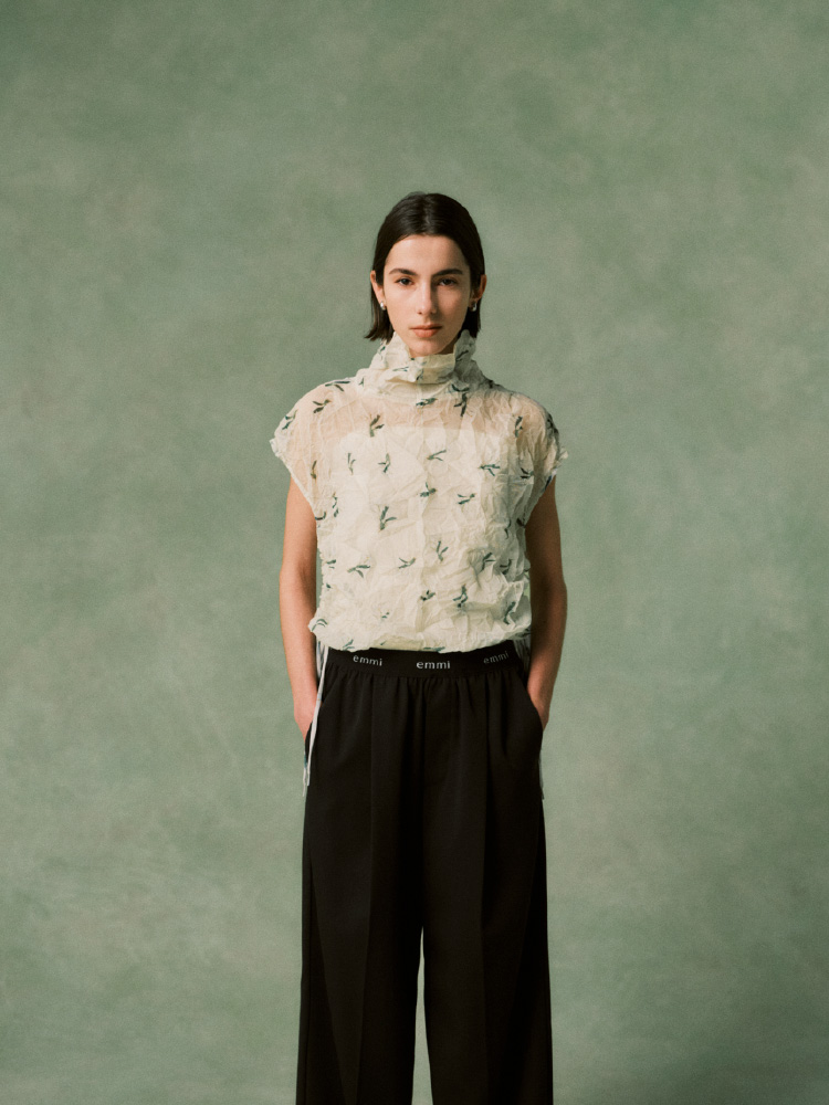 白いトップスに白のパンツを履いた女性の画像