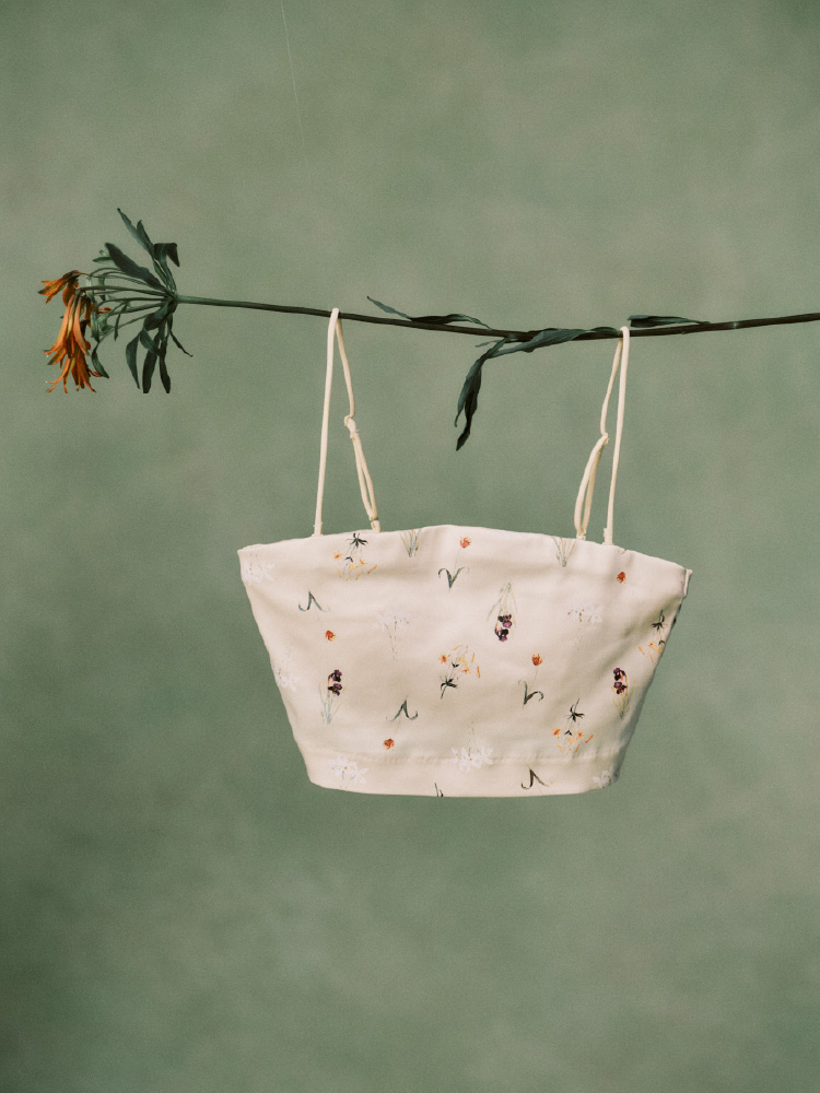 ハート型のエコバックを付けた薄緑のバッグを持った女性の画像