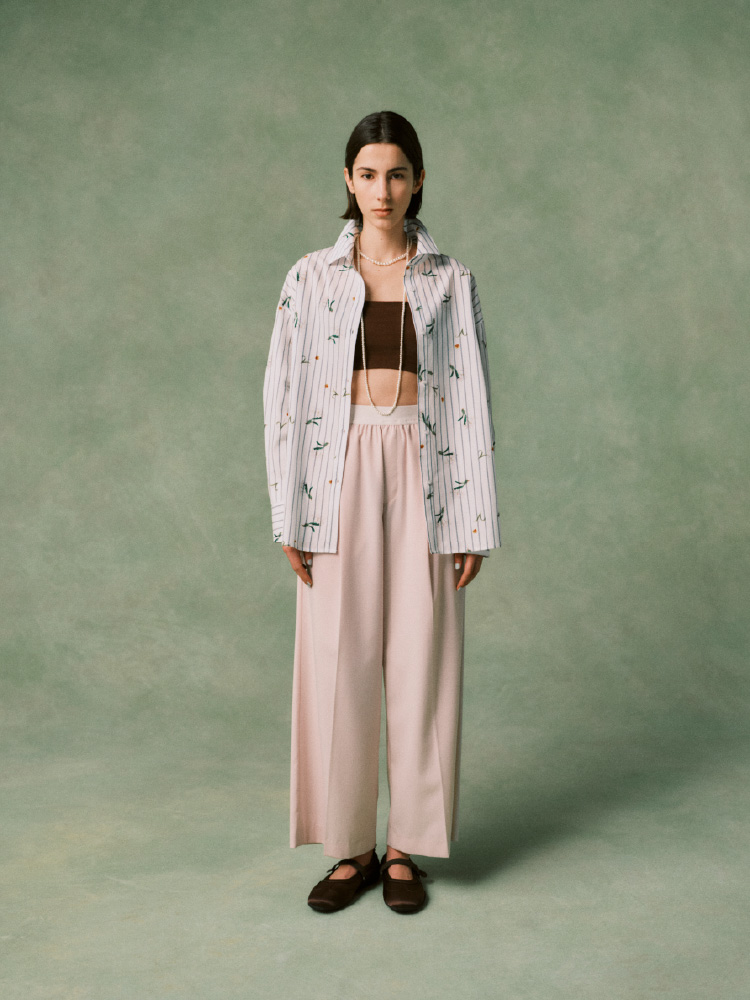 パステルイエローのトップスにロングスカートを着た女性の画像