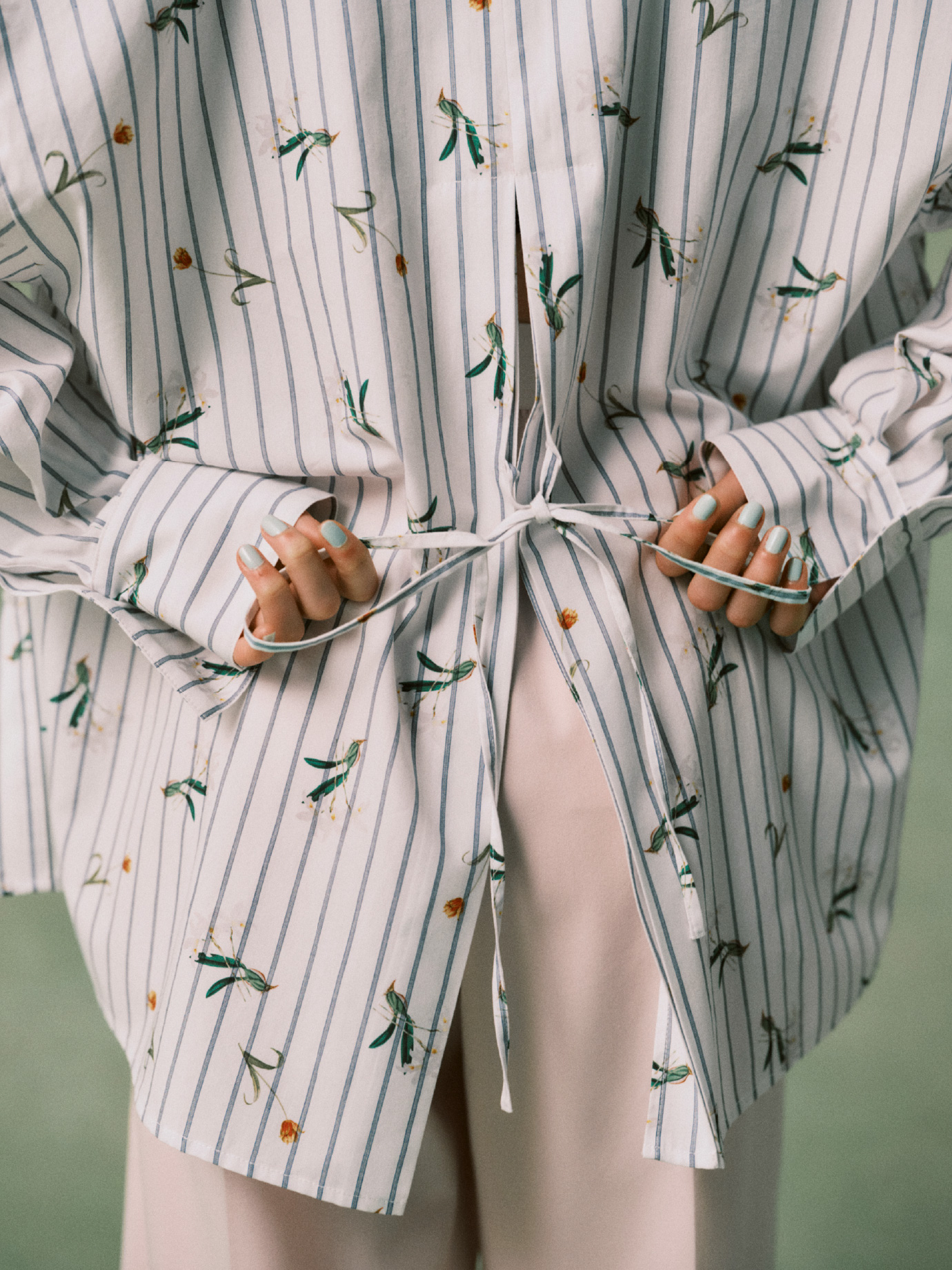 NYBGストライプリラックスシャツ、ピンク色のウエストゴムテーパードパンツを着用した女性の後ろ姿