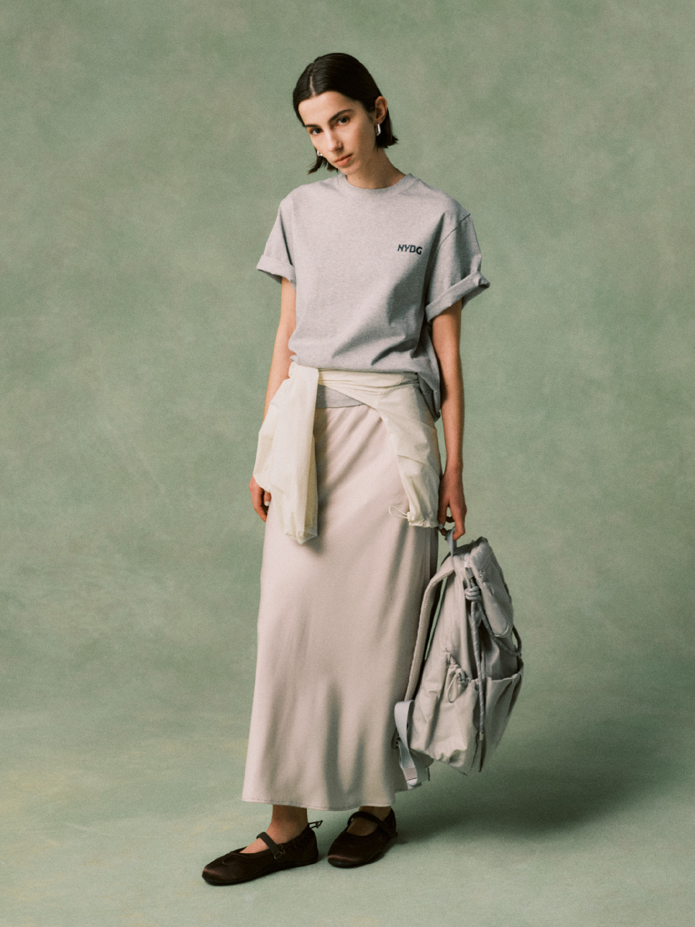 【emmi×NYBG】グラフィックT、ギャザーディテールナイロンブルゾン、ナロースカート、ロングワンタッチピアス、マルチユースバックパック/撥水、【em】サテンメリージェンスニーカーを合わせたコーディネート